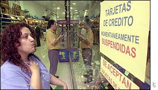 A customer looks at a sign declining to accept credit cards